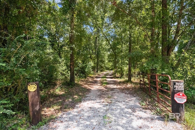 view of street with a gate and a view of trees