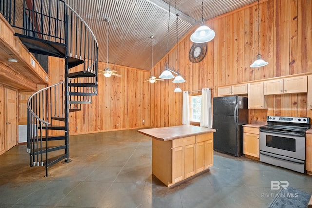 kitchen featuring light brown cabinets, wooden walls, stainless steel electric range, and freestanding refrigerator