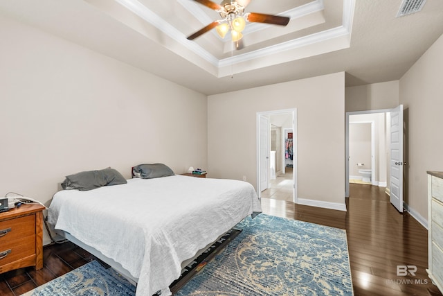 bedroom with visible vents, crown molding, wood finished floors, and a tray ceiling