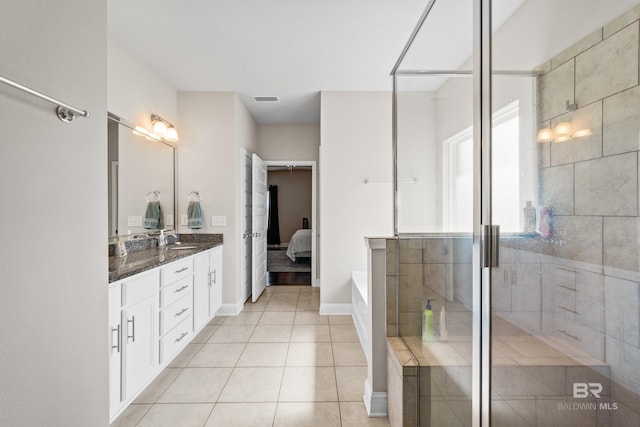 full bathroom featuring visible vents, a stall shower, vanity, baseboards, and tile patterned floors
