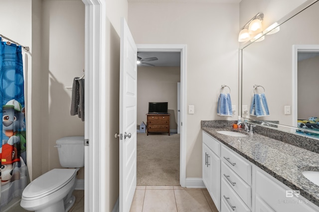 bathroom featuring a sink, baseboards, toilet, and double vanity