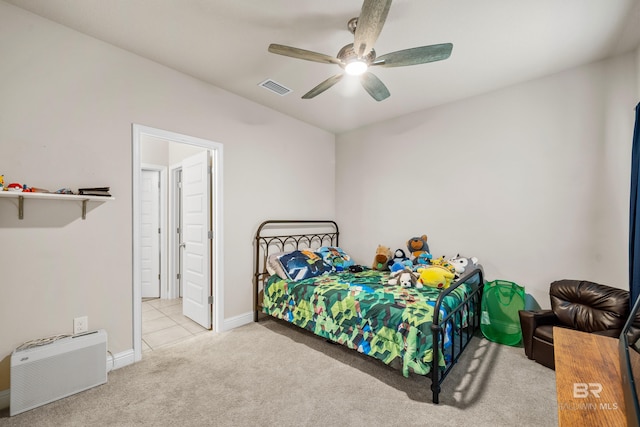 carpeted bedroom with visible vents, baseboards, ceiling fan, and ensuite bath