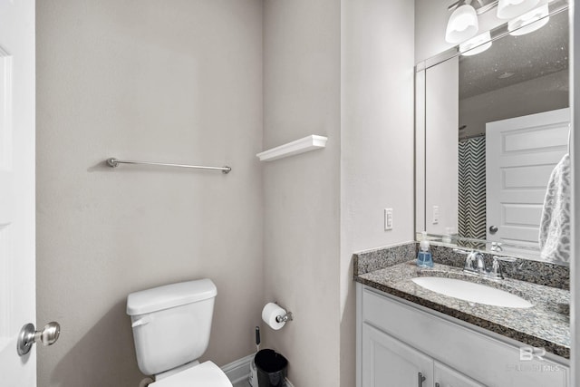 full bath featuring vanity, baseboards, and toilet