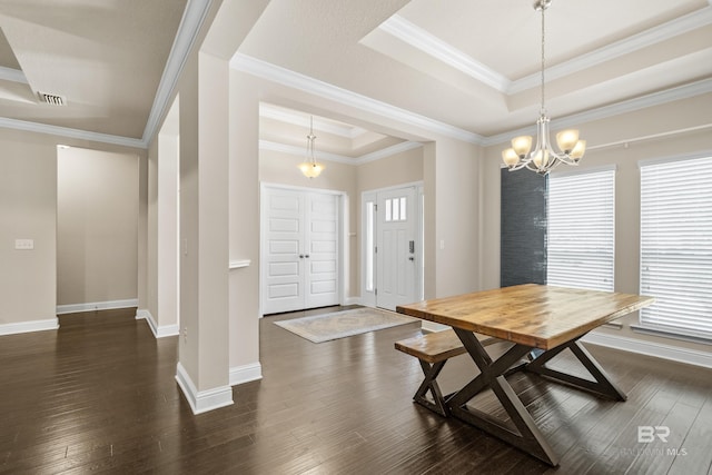 dining room featuring a healthy amount of sunlight, a tray ceiling, dark wood-style floors, and a notable chandelier