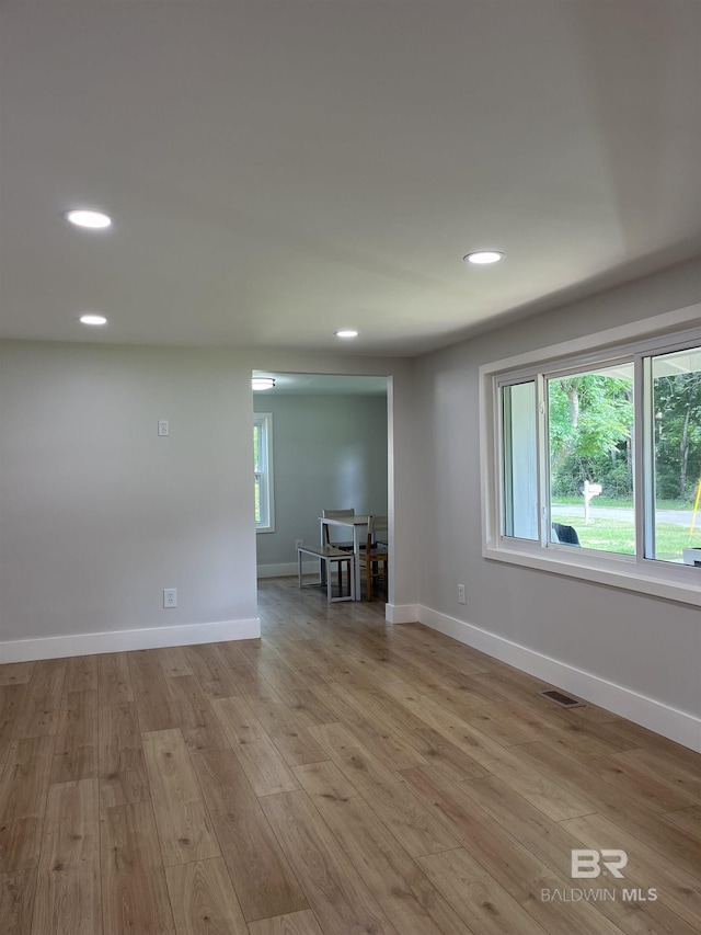 empty room featuring light wood finished floors, baseboards, visible vents, and recessed lighting