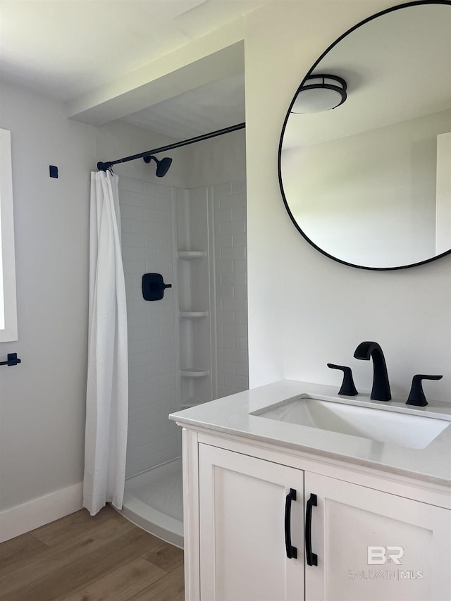 bathroom featuring vanity, a shower stall, and wood finished floors