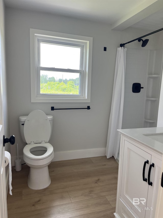 full bath featuring toilet, wood finished floors, vanity, curtained shower, and baseboards