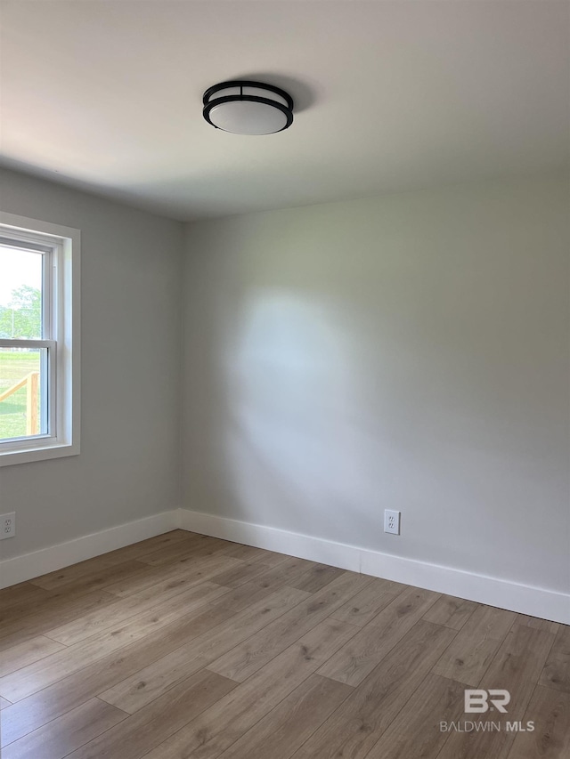 spare room with wood finished floors and baseboards