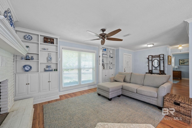 living room featuring ceiling fan, ornamental molding, a textured ceiling, and hardwood / wood-style floors