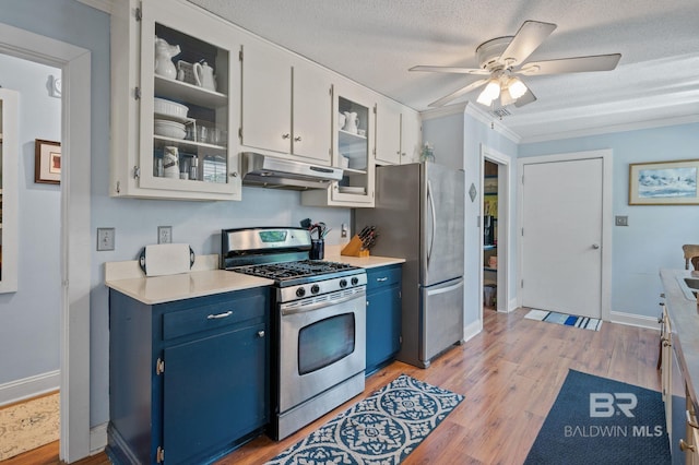 kitchen featuring blue cabinets, light wood-type flooring, stainless steel appliances, white cabinets, and a textured ceiling