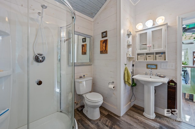 bathroom with hardwood / wood-style floors, vaulted ceiling, walk in shower, and toilet