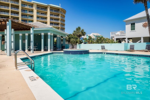 community pool with a patio, fence, and a pergola