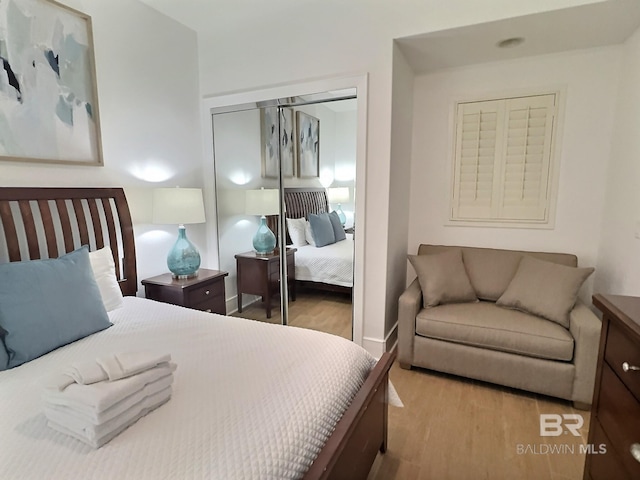 bedroom with wood finished floors and a closet