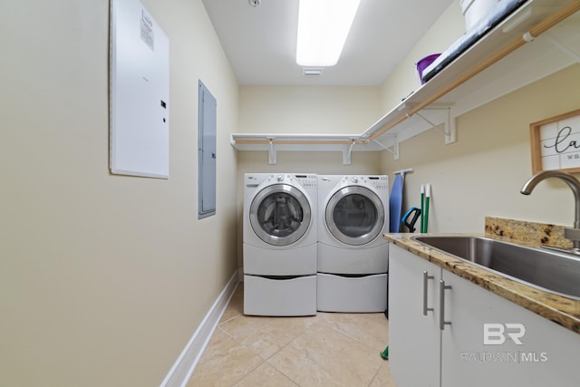 washroom with washing machine and clothes dryer, baseboards, electric panel, light tile patterned flooring, and a sink