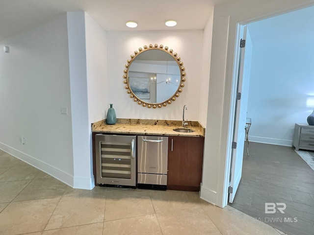 bar featuring beverage cooler, light tile patterned floors, indoor wet bar, and a sink