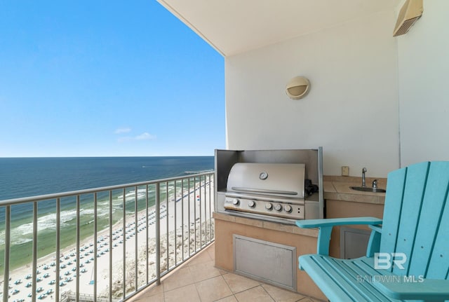 balcony featuring a sink, a beach view, a water view, and grilling area