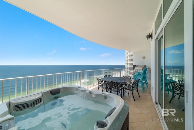 balcony with a hot tub and a water view