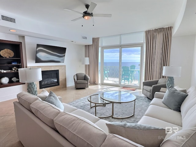 living area featuring visible vents, baseboards, tile patterned flooring, and a tile fireplace