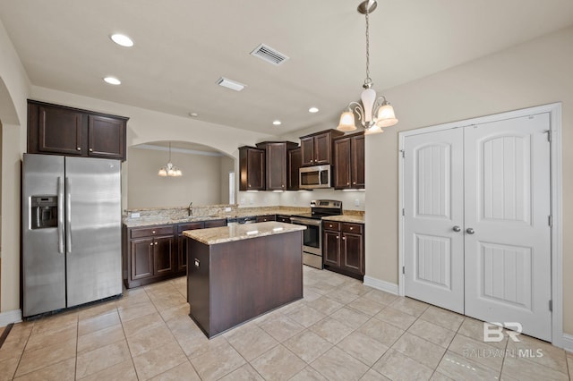 750 Cheswick Ave, Fairhope, AL 36532 - kitchen featuring stainless steel appliances, arched walkways, a chandelier, dark brown cabinetry, and a kitchen island