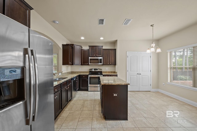 750 Cheswick Ave, Fairhope, AL 36532 - kitchen featuring stainless steel appliances, light tile patterned floors, a chandelier, dark brown cabinetry, and a kitchen island