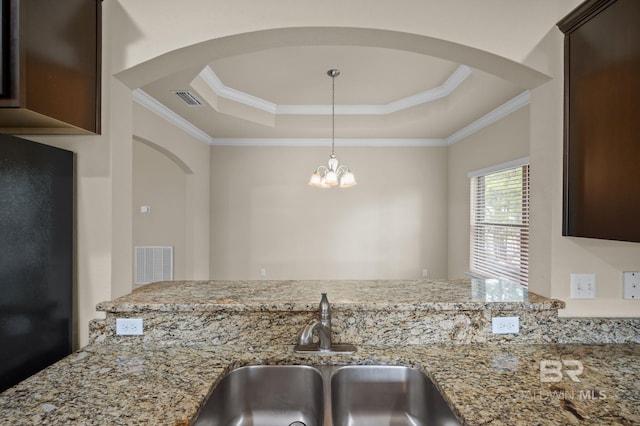 750 Cheswick Ave, Fairhope, AL 36532 - kitchen featuring arched walkways, a tray ceiling, a sink, dark brown cabinets, and crown molding