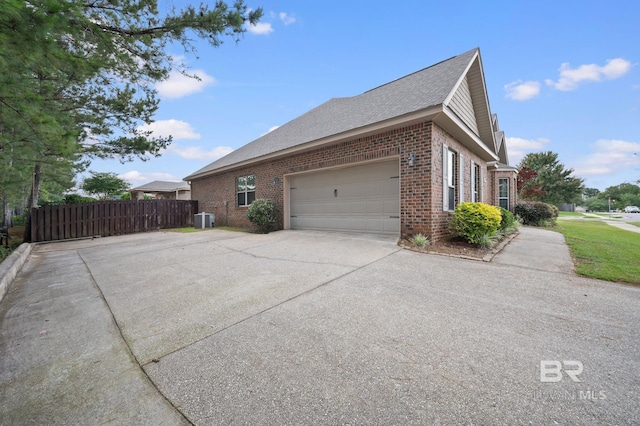 750 Cheswick Ave, Fairhope, AL 36532 - view of property exterior featuring brick siding, concrete driveway, an attached garage, central AC, and roof with shingles