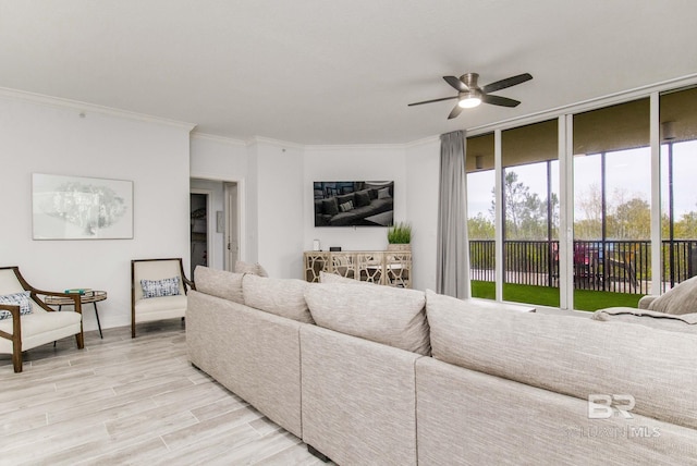 living room featuring ceiling fan, ornamental molding, and light hardwood / wood-style floors