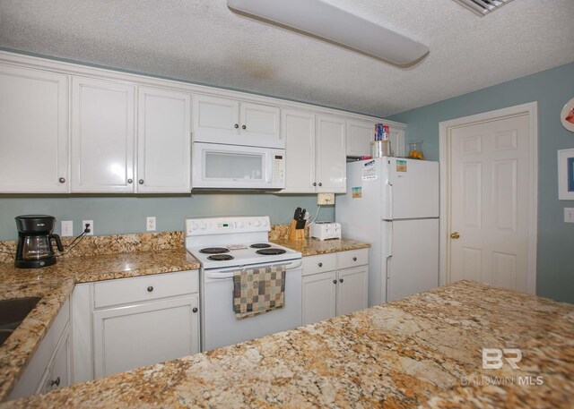 527 Beach Club Trl Unit C1006, Gulf Shores, AL 36542 - kitchen with white cabinetry, light stone countertops, white appliances, and a textured ceiling