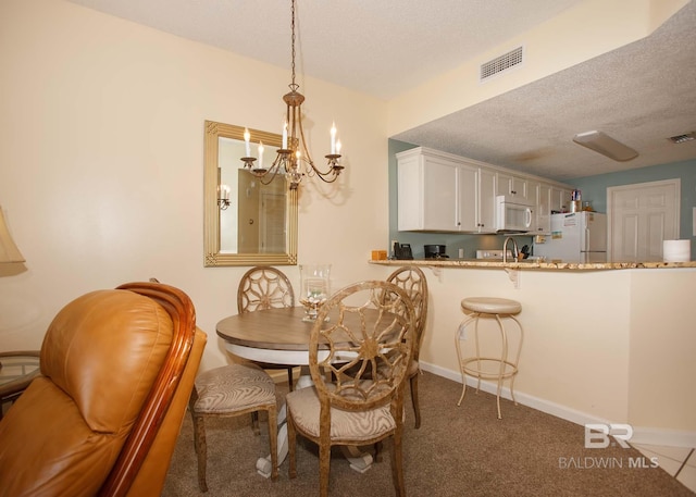 527 Beach Club Trl Unit C1006, Gulf Shores, AL 36542 - dining room featuring a textured ceiling, visible vents, a notable chandelier, and baseboards