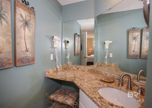 527 Beach Club Trl Unit C1006, Gulf Shores, AL 36542 - ensuite bathroom with ensuite bath, a textured ceiling, and vanity