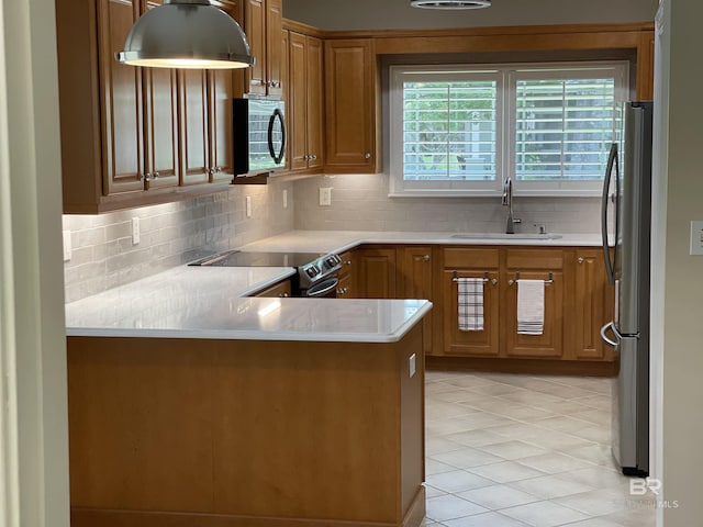 kitchen with kitchen peninsula, appliances with stainless steel finishes, backsplash, and sink