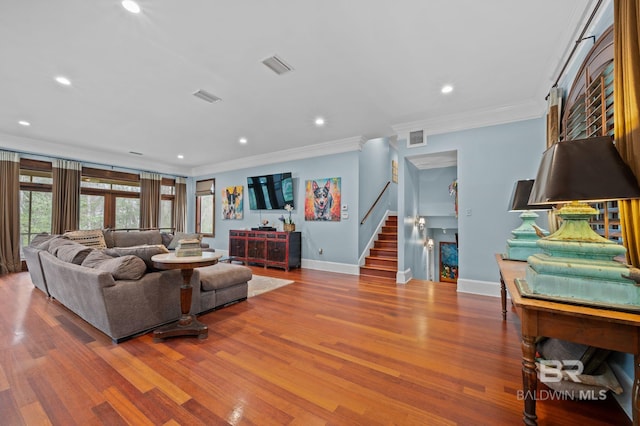 living room featuring stairway, wood finished floors, and visible vents