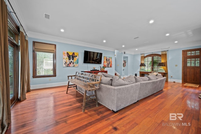 living area with visible vents, wood finished floors, crown molding, and stairway