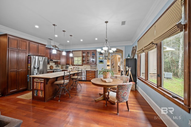 dining room with visible vents, dark wood-style floors, arched walkways, crown molding, and a chandelier