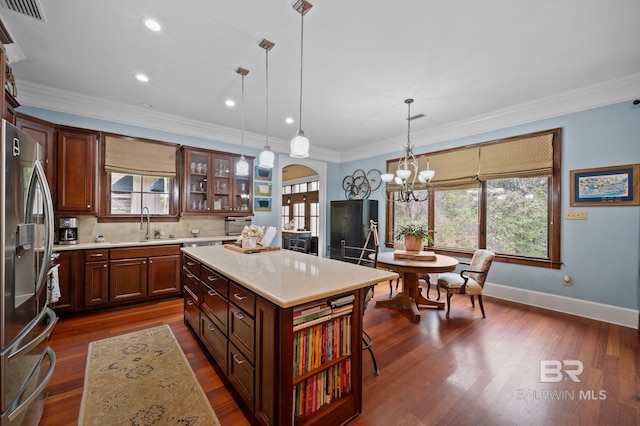 kitchen featuring visible vents, stainless steel fridge with ice dispenser, light countertops, ornamental molding, and arched walkways