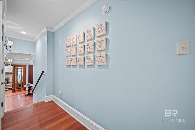 corridor featuring dark wood finished floors, crown molding, an upstairs landing, and baseboards