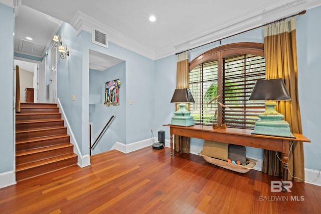 office featuring visible vents, baseboards, attic access, ornamental molding, and wood finished floors