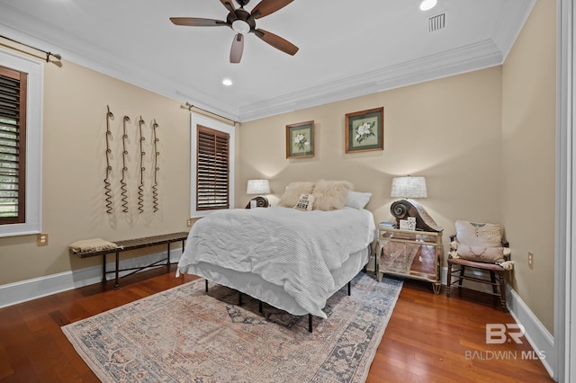 bedroom featuring visible vents, wood-type flooring, baseboards, and crown molding