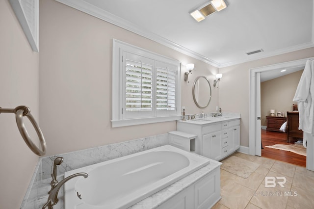 ensuite bathroom with double vanity, visible vents, a bath, and crown molding