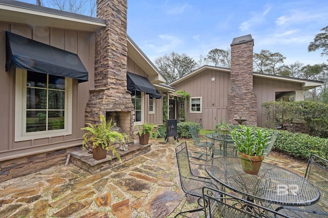 view of patio / terrace featuring outdoor dining area and an outdoor stone fireplace