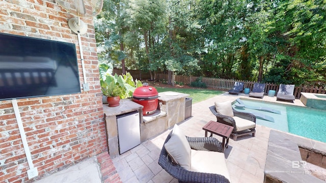 view of patio / terrace featuring a fenced in pool, exterior kitchen, and a grill