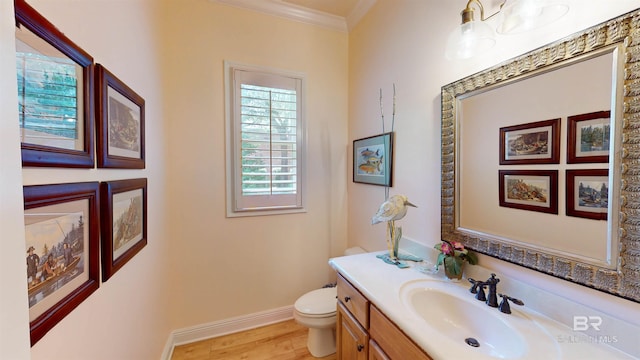 bathroom featuring hardwood / wood-style floors, vanity, toilet, and crown molding