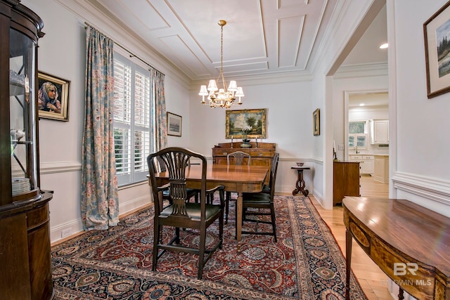 dining area with an inviting chandelier, ornamental molding, and light hardwood / wood-style flooring