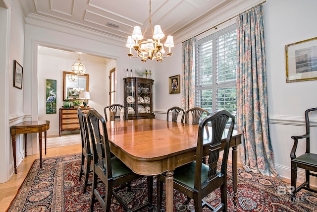 dining space with light wood-type flooring, a chandelier, and crown molding