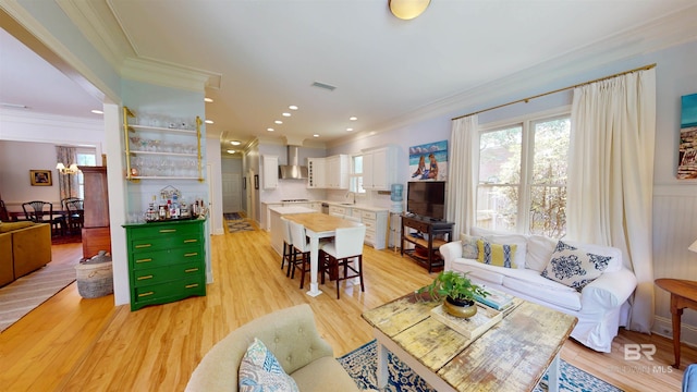 living room with light hardwood / wood-style flooring, sink, and crown molding