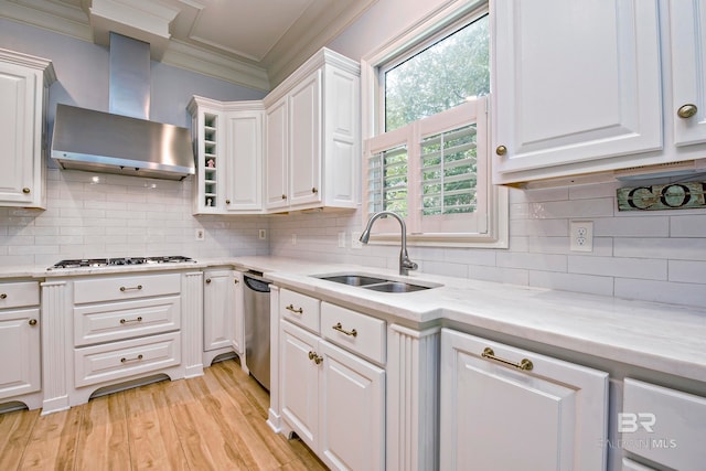 kitchen featuring white cabinetry, appliances with stainless steel finishes, sink, light hardwood / wood-style floors, and wall chimney exhaust hood