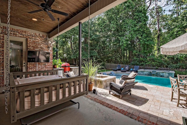 view of patio / terrace with a fenced in pool, area for grilling, ceiling fan, and pool water feature