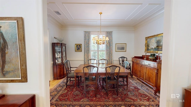 dining room featuring an inviting chandelier, hardwood / wood-style flooring, and crown molding