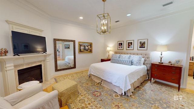 bedroom with ornamental molding, a fireplace, and an inviting chandelier