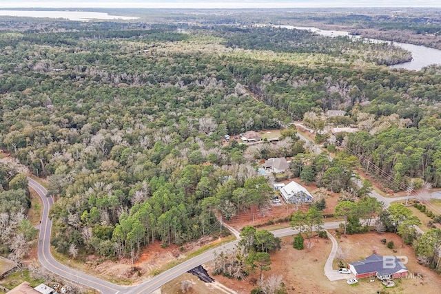 birds eye view of property with a water view and a wooded view